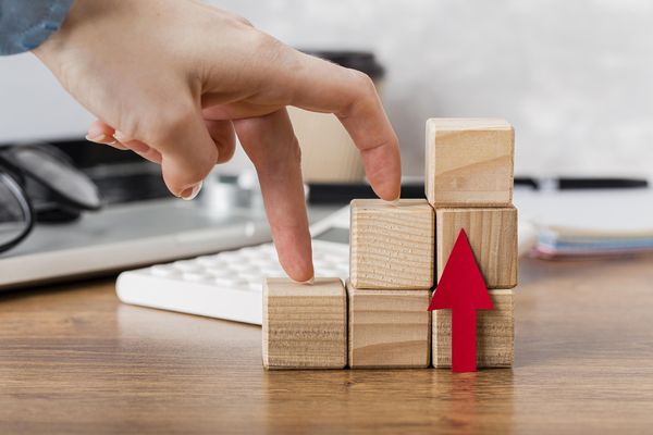 hand climbing wooden blocks represent growth