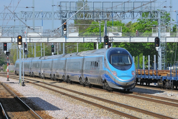 Pendolino stacji Grodzisk Mazowiecki, w tle pociąg towarowy